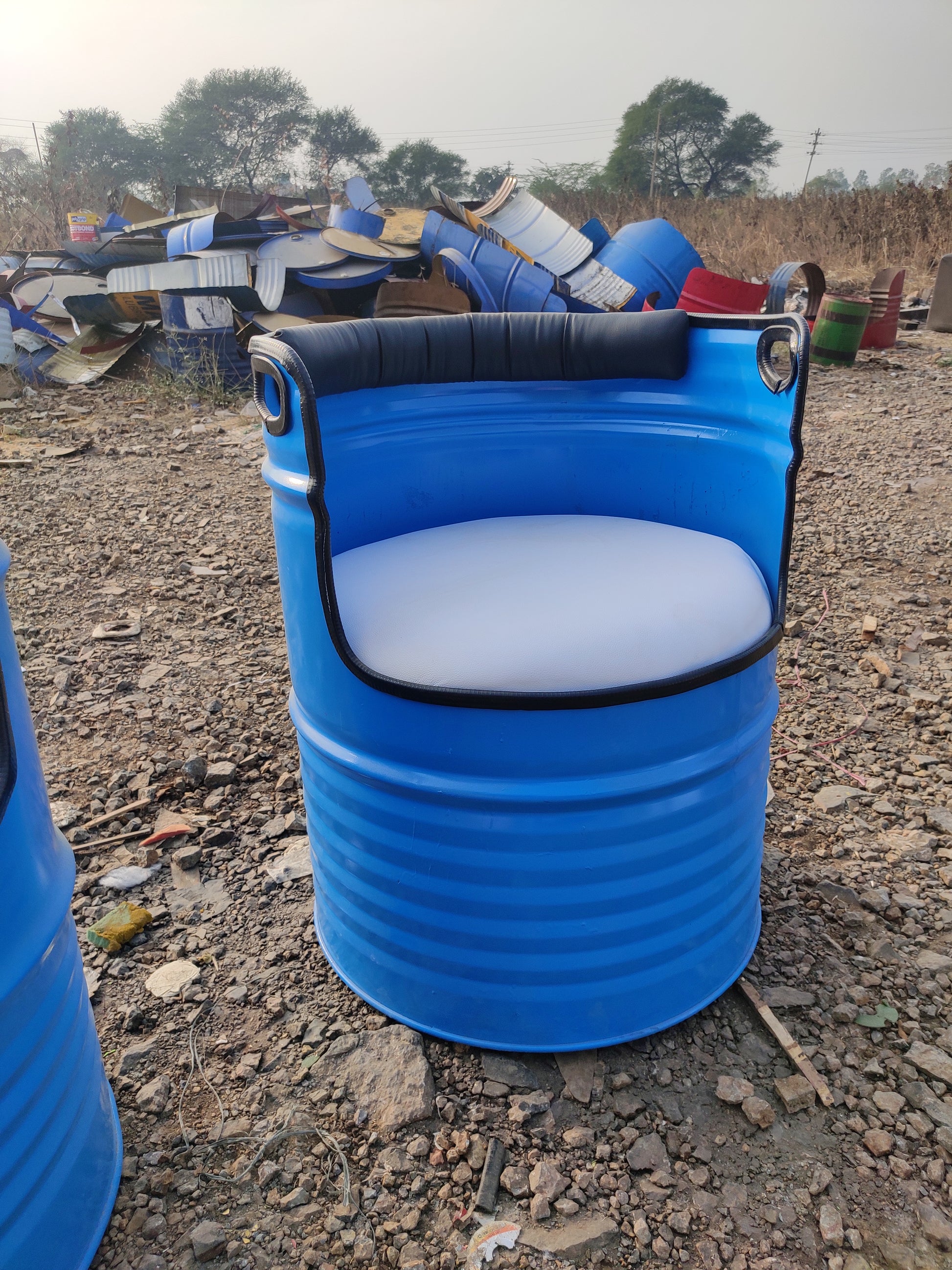 Blue Gigantiques barrel chair in rustic setting, showcasing upcycled furniture design by innovative manufacturer in Mumbai, India.